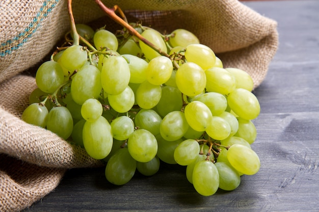 Cacho de uvas verdes sobre fundo de madeira