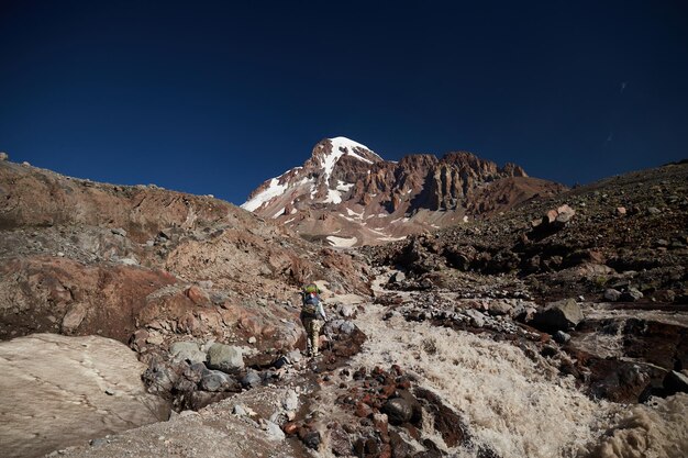 Cachoeira da geleira gergeti natureza das montanhas caucasianas estrada para o acampamento base na expedição alpinista kazbek georgia mount kazbek