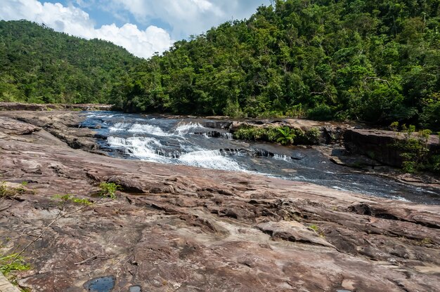 Cachoeira Kanpire fluindo sobre uma plataforma de pedra na selva