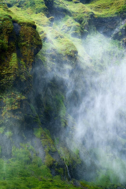 Cachoeira misteriosa fluindo com neblina em um desfiladeiro exuberante