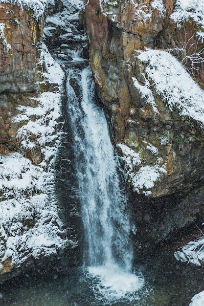 Cachoeira nas montanhas nevadas durante o inverno