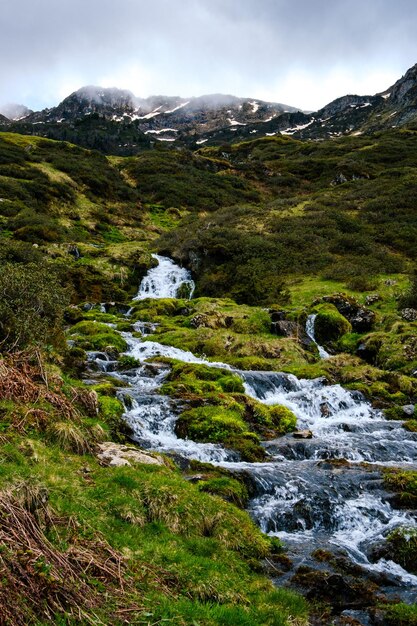 Cachoeira no caminho de caminhada para o lago Ayes nas montanhas francesas dos Pirenéus em um dia nublado