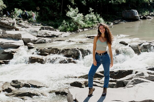 Cachoeira no rio de montanha. menina viajando nas montanhas do karpathian e sentindo liberdade.