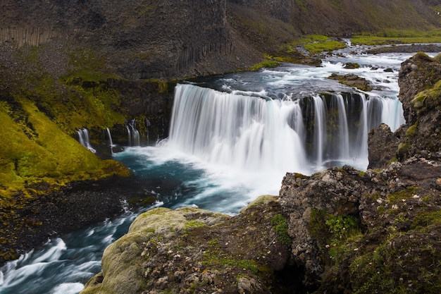 Foto cachoeira numa paisagem de pedras de lava pedras no terreno