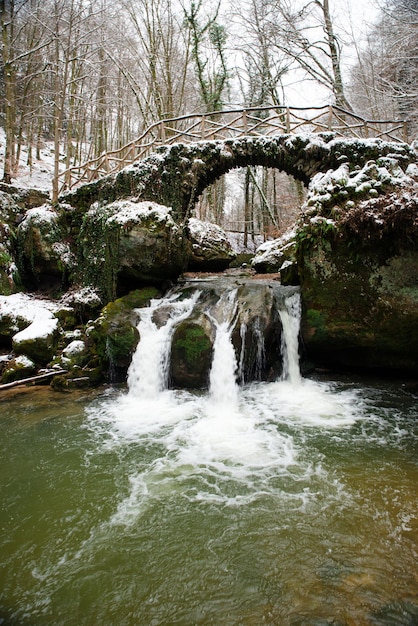 Cachoeira Scheissendempel, rio Black Ernz com ponte de pedra coberta de neve, trilha Mullerthal