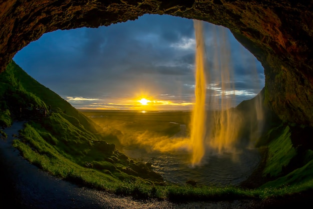 Cachoeira Seljalandsfoss tendo como pano de fundo um pôr do sol brilhante. Islândia