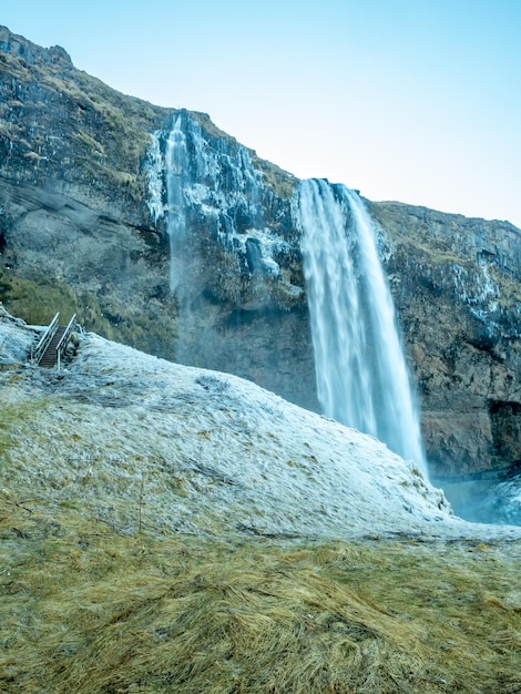 Cachoeira Siljalandsfoss na Islândia grande cachoeira com penhasco natural com neve e gelo ao redor