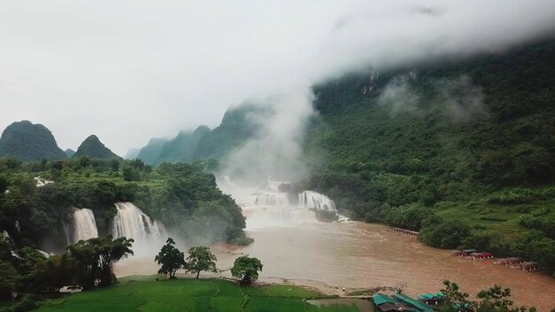 Foto cachoeiras do rio brown, vegetação densa, árvores, nuvens, montanhas