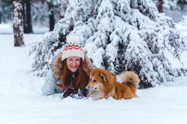 Cachorro corgi fofo e seu dono brincando em uma caminhada de inverno ao ar livre