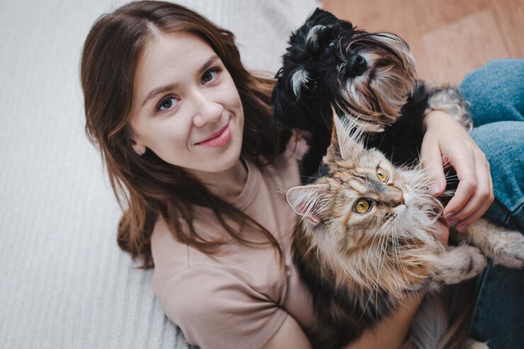 cachorro e um gato nas mãos de seu dono