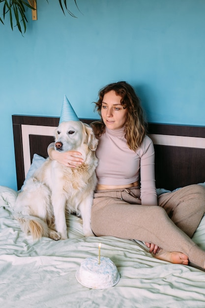 Cachorro labrador golden retriever comemora aniversário com chapéu e bolo