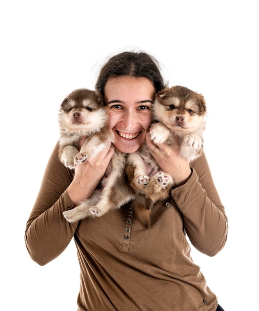 Cachorro Lapphund finlandés y propietario delante de un fondo blanco