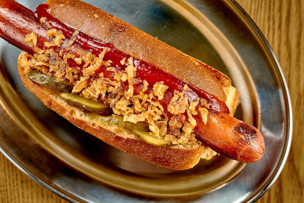 Cachorro-quente com cebola caramelizada com ketchup Foco seletivo closeup Ruído adicionado na pós-produção