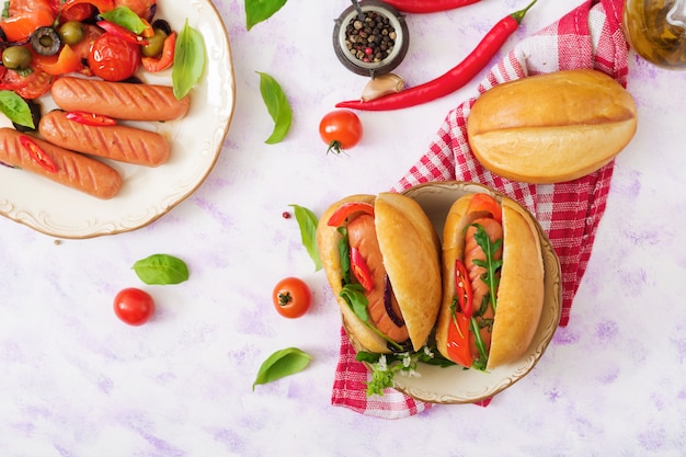 Cachorro-quente com linguiça e legumes no estilo grego.