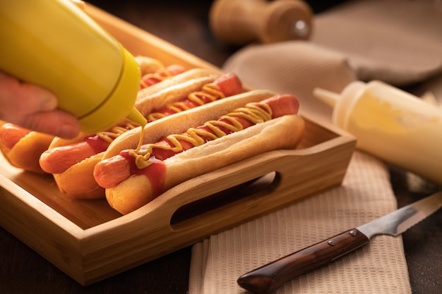 Foto cachorro-quente com pimenta, tomate, alface e salada misturam na madeira.