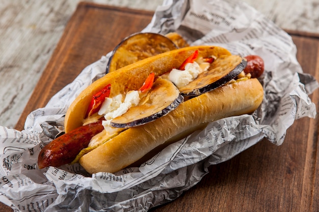 cachorro-quente com salsicha, berinjela, queijo cottage, tomate e pimenta