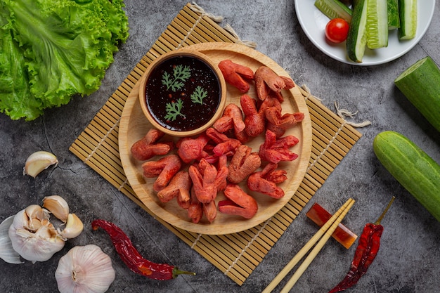 Cachorro-quente frito ou salsichas na superfície escura.