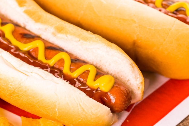 Foto cachorro-quente grelhado no pão de cachorro-quente branco com mostarda e ketchup.