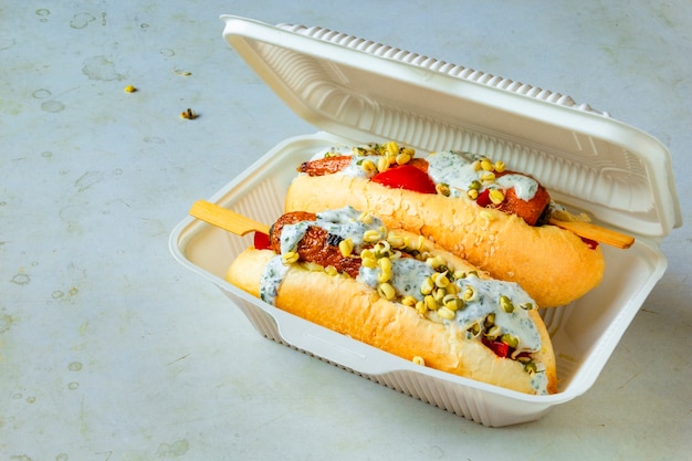 Cachorro-quente vegan de cenoura. Talheres descartáveis com comida de rua vegetariana. Conceito de refeição sem carne baseado em planta saudável.