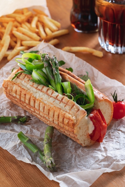 Cachorro-quente vegetariano caseiro com rúcula de aspargos e tomate temperado com pesto