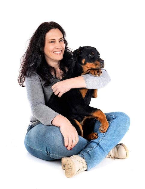 Cachorro rottweiler y mujer delante de un fondo blanco