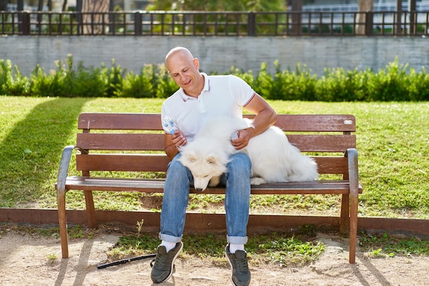 Foto cachorro samoiedo com seu dono no parque brincando juntos