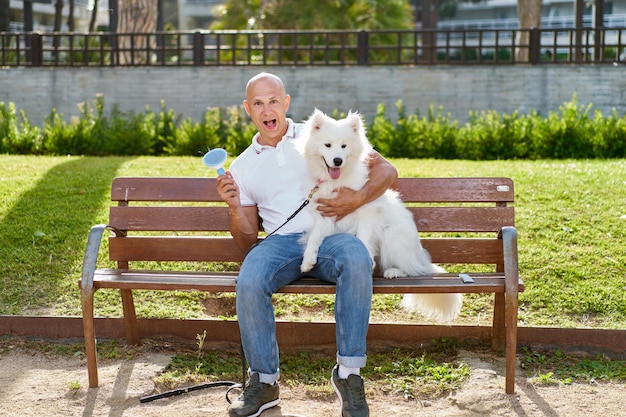 Cachorro samoiedo com seu dono no parque brincando juntos