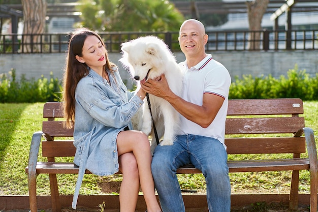 Cachorro samoiedo com sua dona no parque brincando juntos