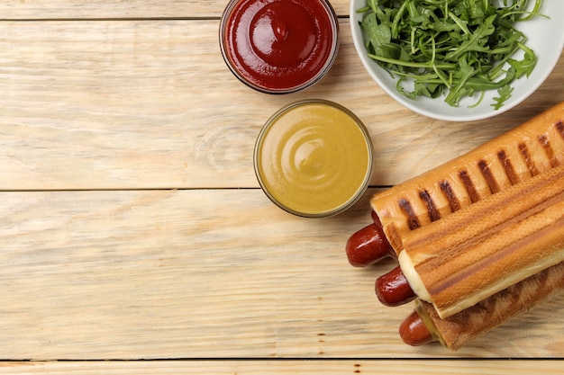 Cachorros-quentes franceses. deliciosos cachorros-quentes e ketchup, maionese e mostarda em uma mesa de madeira natural. comida de rua de fast food. salsichas em um pão. vista do topo