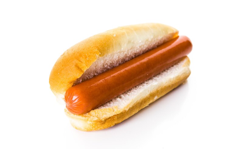 Foto cachorros-quentes tradicionais em um pão de cachorro-quente branco sobre um fundo branco.
