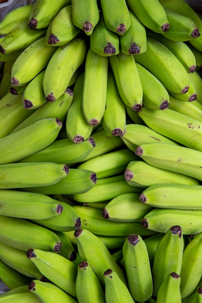 Cachos de banana verde em uma barraca de mercado ao ar livre