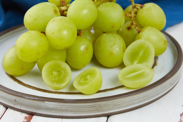 Cachos de uvas verdes maduras frescas em uma mesa de madeira