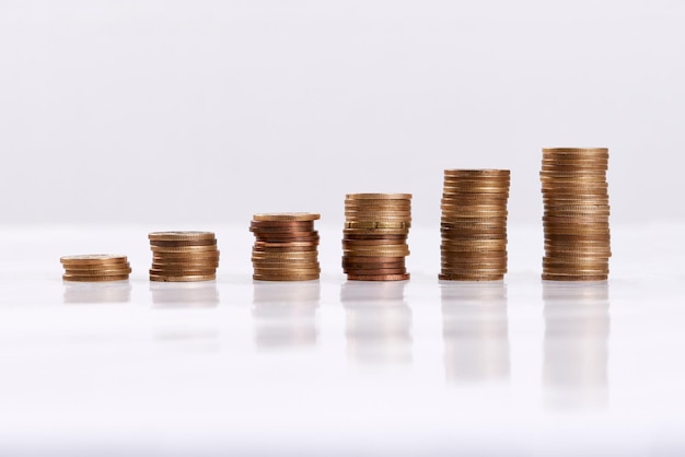 Cada poquito ayuda Foto de estudio de columnas de monedas aisladas en un fondo blanco