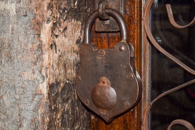 Cadeado grande e velho na porta de madeira