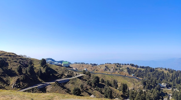 Foto cadeias de montanhas, folhagem verde e caminho curvo