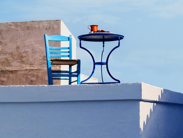 Cadeira azul de mesa e um jarro de vinho para relaxar ao meio-dia nas ilhas gregas Skopelos na Grécia