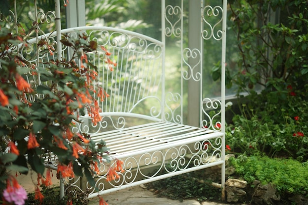 Cadeira de assento de metal branco no parque do jardim de flores na primavera verão