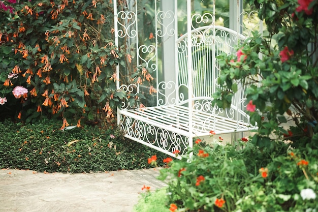 Cadeira de assento de metal branco no parque do jardim de flores na primavera verão