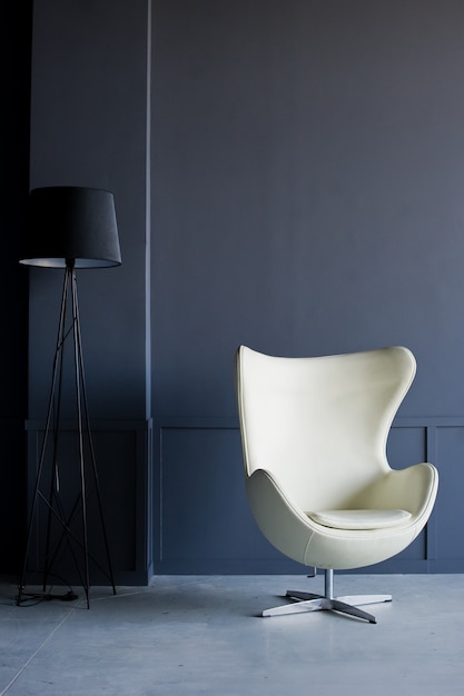 Cadeira de designer branca no interior de um loft preto Studio