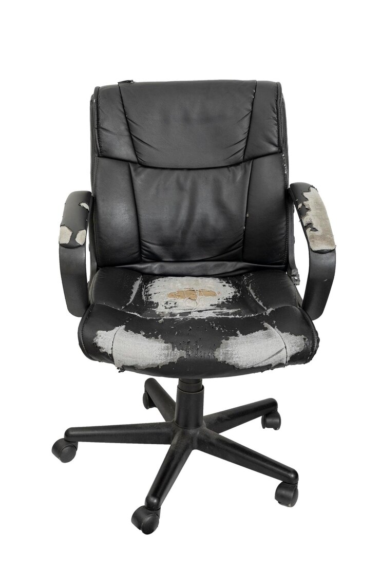 Cadeira de escritório velha e desgastada pelo uso em uma vista frontal de fundo branco