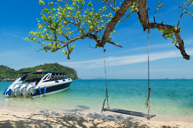 Foto cadeira de madeira do balanço que pendura na árvore perto da praia na ilha em phuket, tailândia.