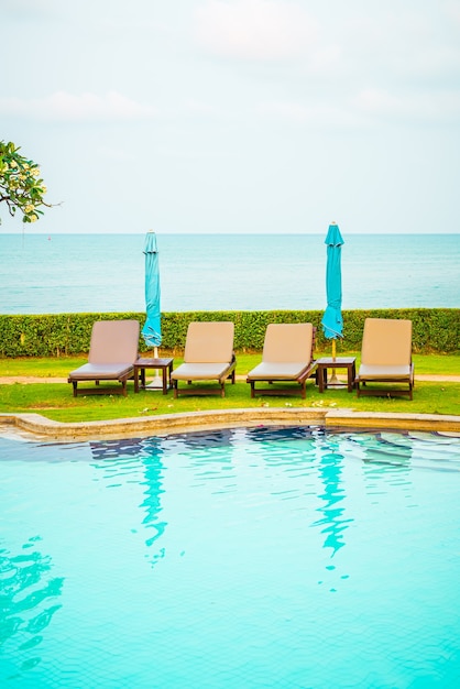 cadeira de piscina com guarda-sol ao redor da piscina