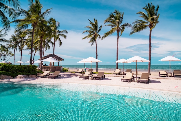 cadeira de praia ao redor da piscina em hotel resort com praia