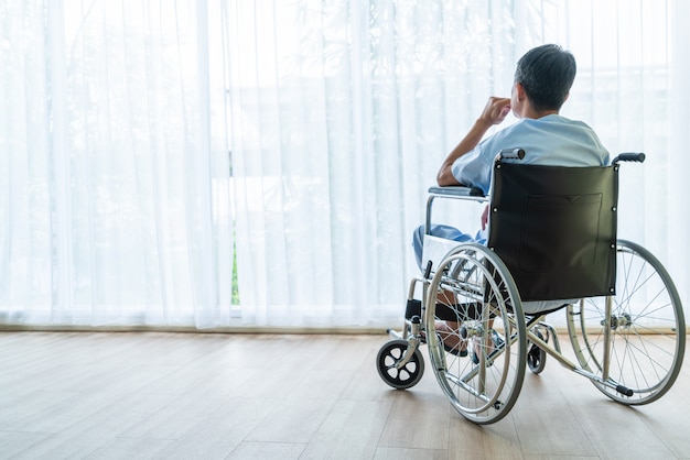 Cadeira de rodas paciente asiática no quarto vazio