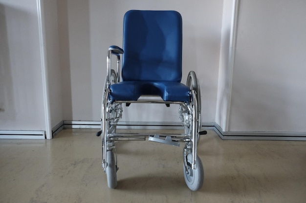 Foto cadeira de rodas vazia contra a parede no hospital
