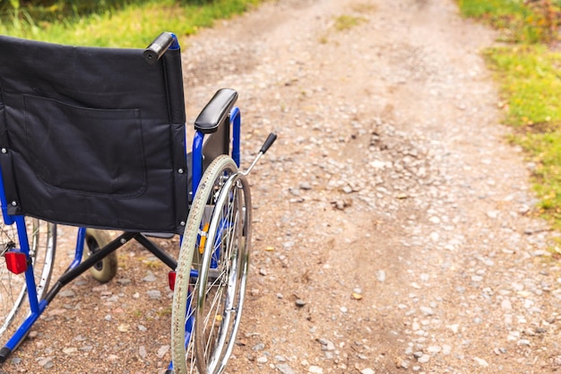Cadeira de rodas vazia em pé na estrada à espera de cadeira de rodas de serviços ao paciente para pessoas com di...