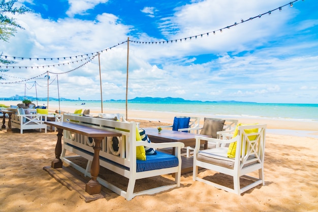 Cadeira e mesa de jantar na praia e no mar com céu azul