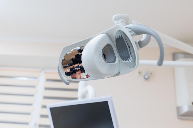 Cadeira odontológica de clínica odontológica moderna e outros acessórios usados por dentistas em luz médica