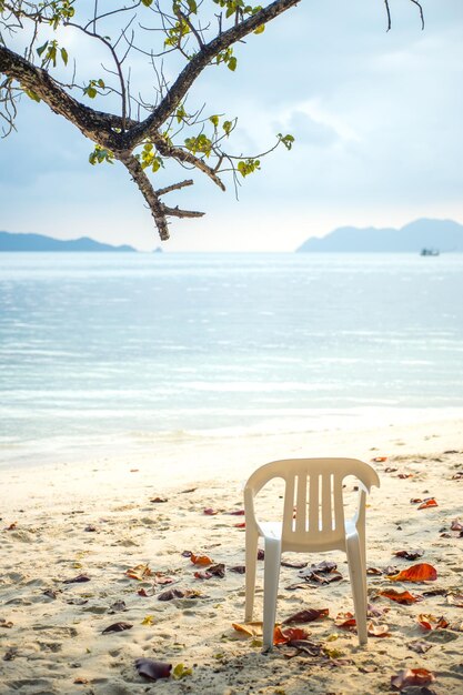 Foto cadeira vazia na areia da praia