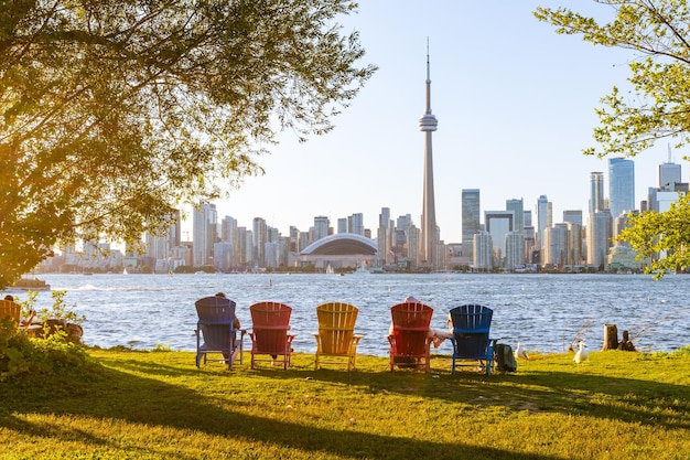 Cadeiras adirondack coloridas no Toronto Island Park ao pôr do sol no horizonte do centro da cidade de Toronto